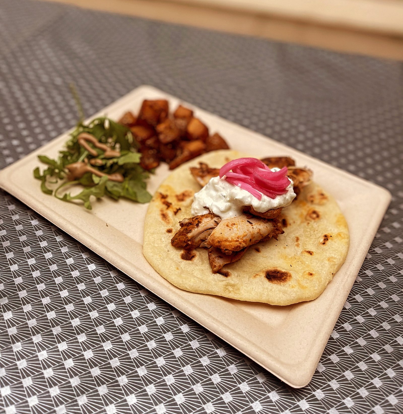 Greek chicken on flatbread with tzatziki and pickled red onions